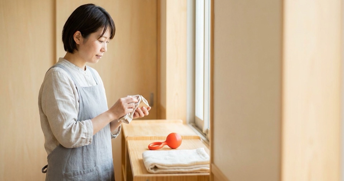 やわらかな粘土質感の木製おもちゃとたたんだ和紙の毛布を並べた静物イメージ